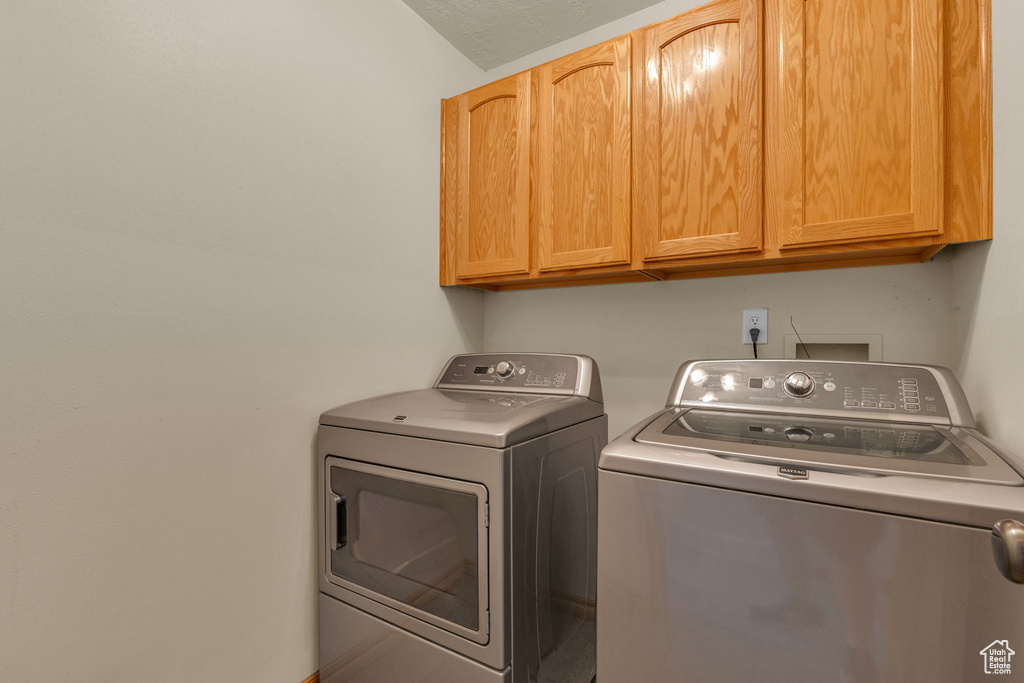 Washroom with cabinet space and independent washer and dryer