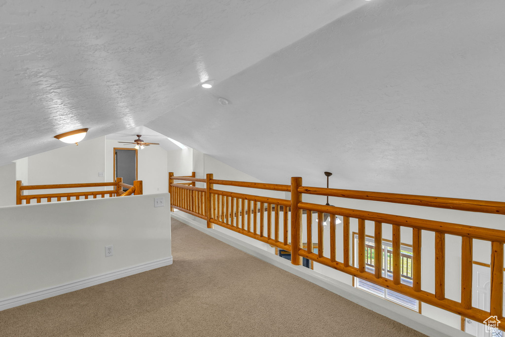Hall featuring vaulted ceiling and carpet floors
