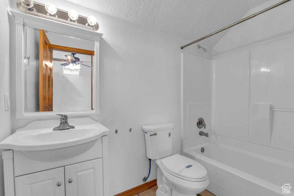 Bathroom with vanity, ceiling fan, a textured ceiling, and bathing tub / shower combination