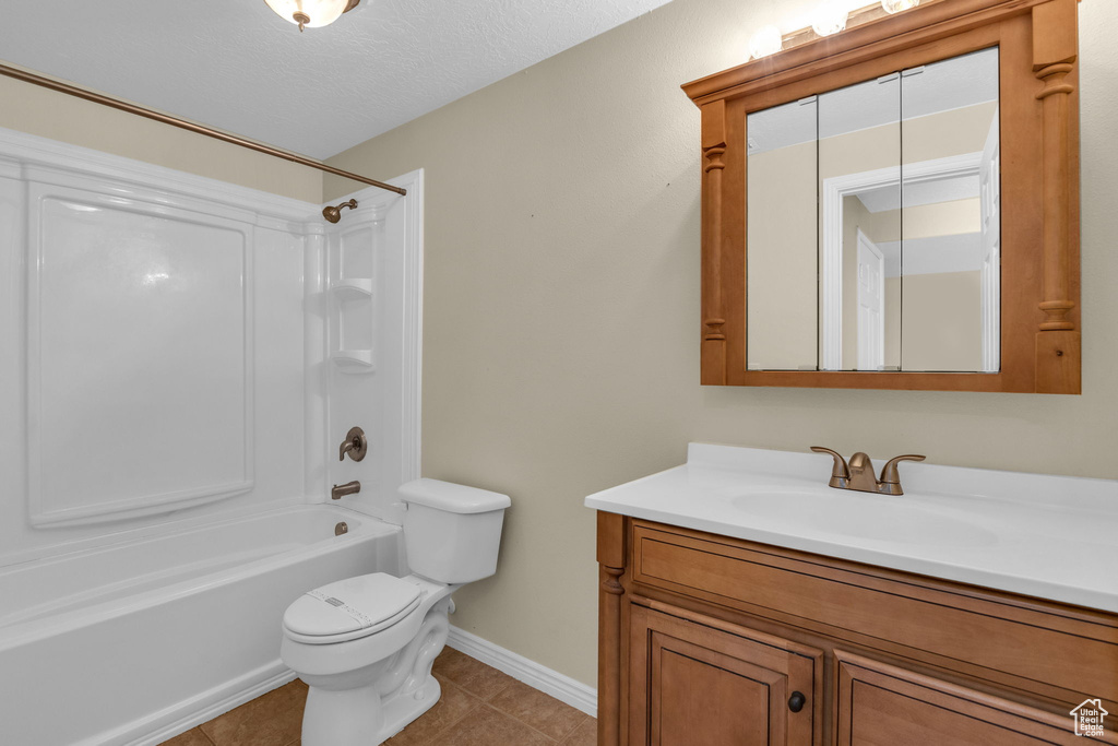 Bathroom featuring vanity, shower / washtub combination, tile patterned floors, and a textured ceiling