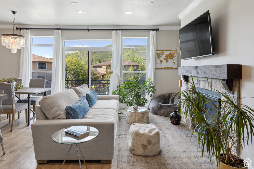 Living room featuring a chandelier, wood finished floors, recessed lighting, and crown molding
