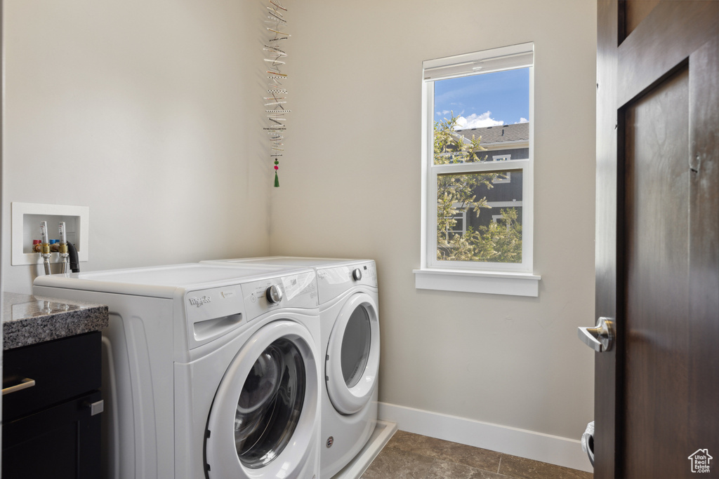 Laundry room featuring separate washer and dryer and cabinet space