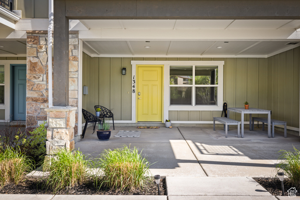 View of exterior entry with a porch and stone siding