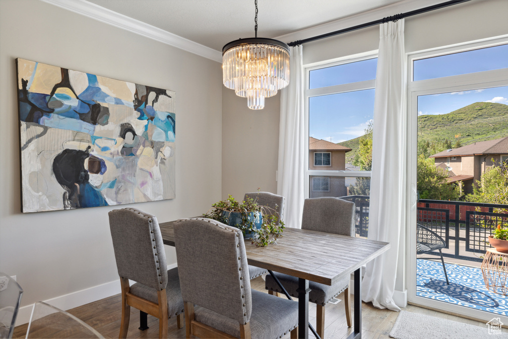Dining room featuring a chandelier, ornamental molding, wood finished floors, and a mountain view