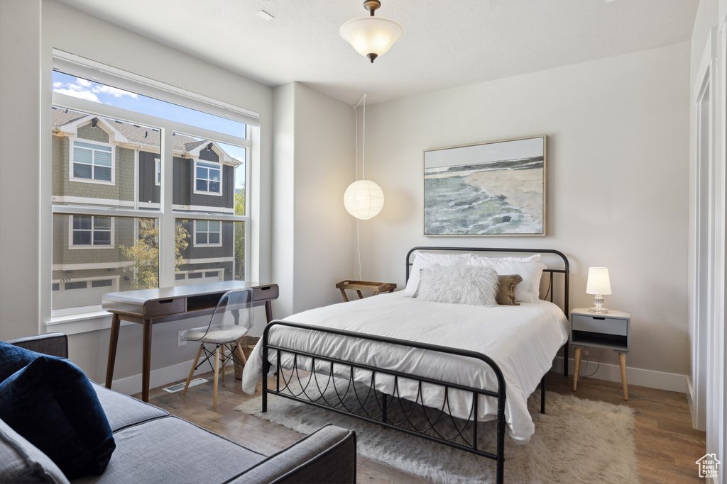 Bedroom with wood finished floors and baseboards
