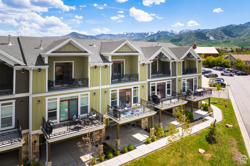 View of front of house featuring a mountain view, board and batten siding, and a shingled roof