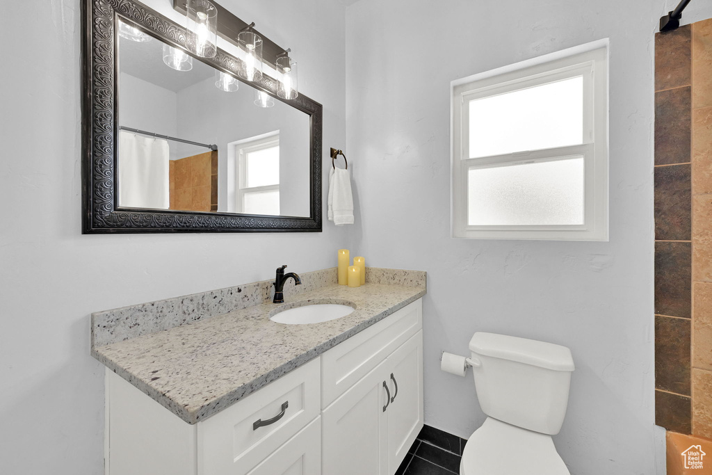 Full bath featuring vanity, healthy amount of natural light, a shower with shower curtain, and tile patterned floors