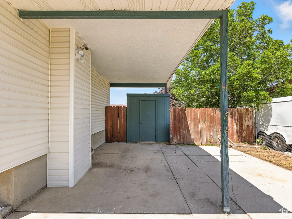 View of patio / terrace featuring a storage unit and an attached carport
