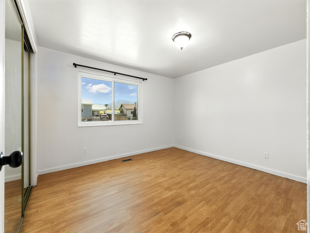 Unfurnished room with light wood-style floors and baseboards