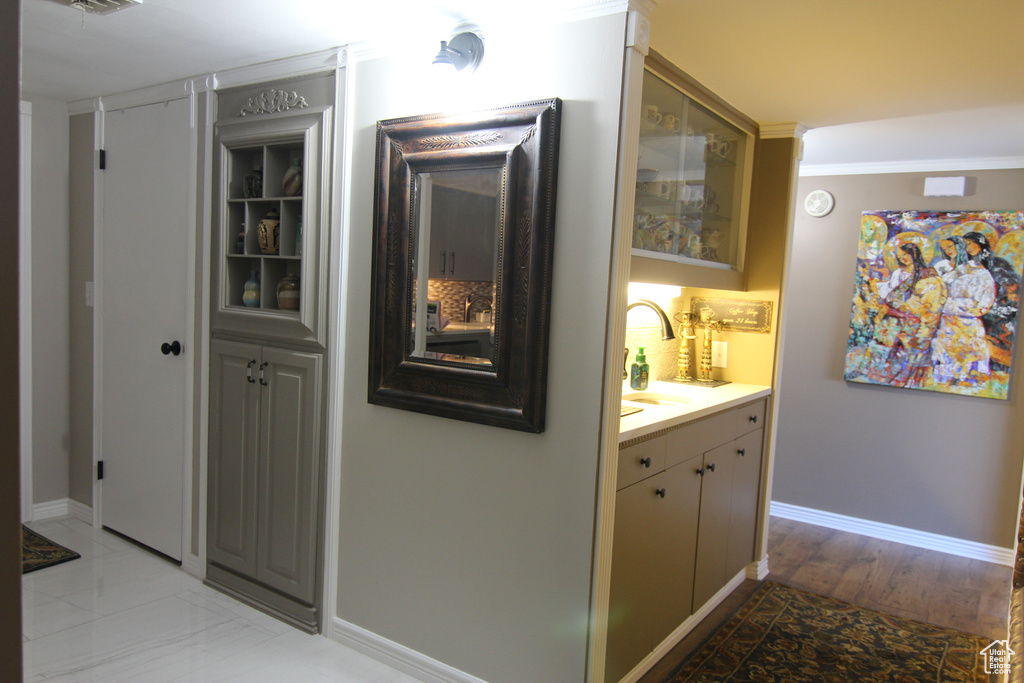 Hallway with a sink and baseboards