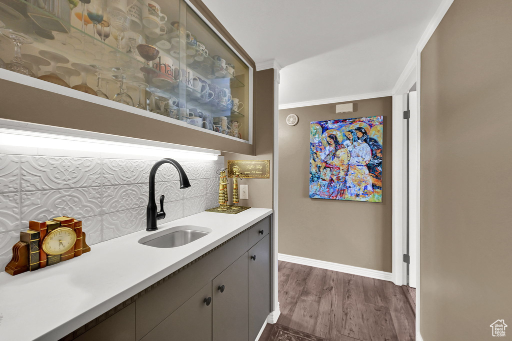 Bar area featuring decorative backsplash and dark wood finished floors