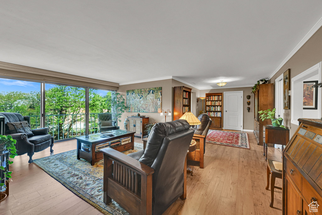Living area featuring ornamental molding and light wood-type flooring