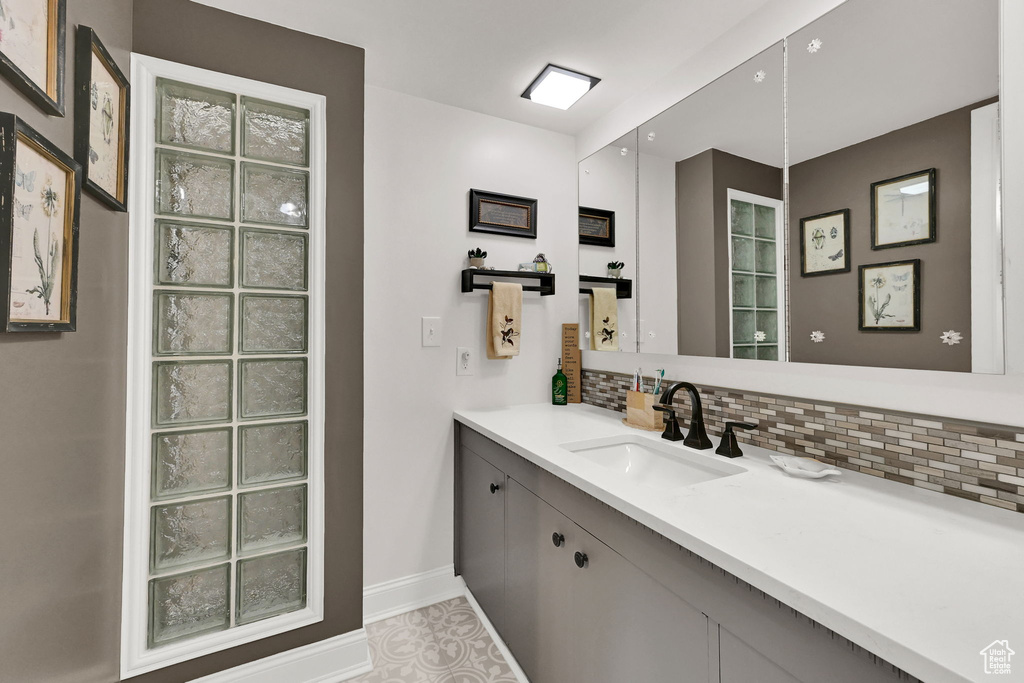 Bathroom featuring decorative backsplash and vanity