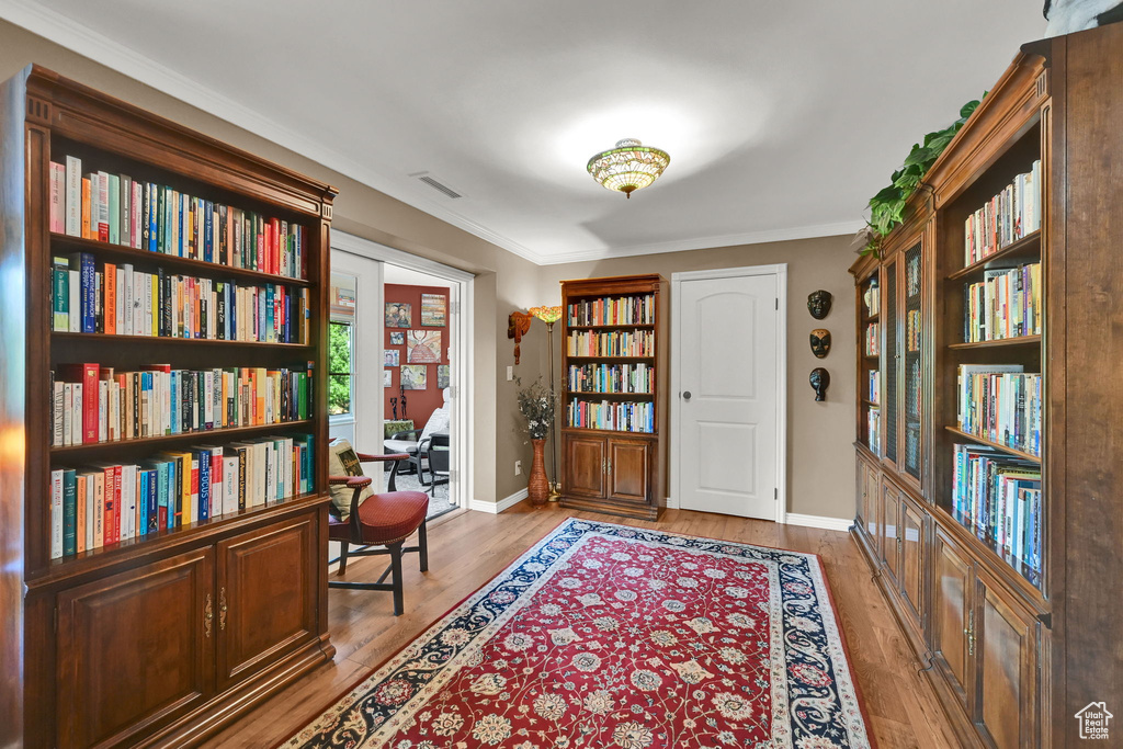 Entrance foyer with wood finished floors and crown molding