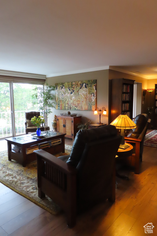 Living room with wood-type flooring and crown molding