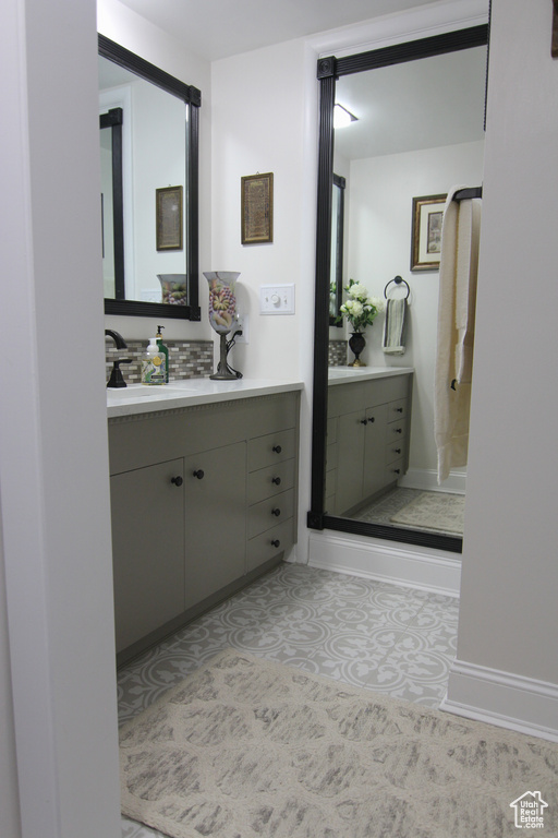 Bathroom featuring vanity and tasteful backsplash