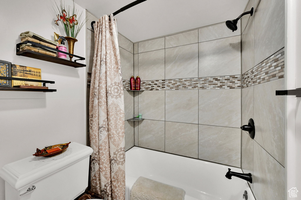 Bathroom featuring shower / bath combo and toilet