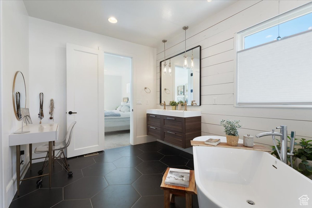 Full bathroom featuring a freestanding bath, ensuite bathroom, vanity, wood walls, and tile patterned flooring