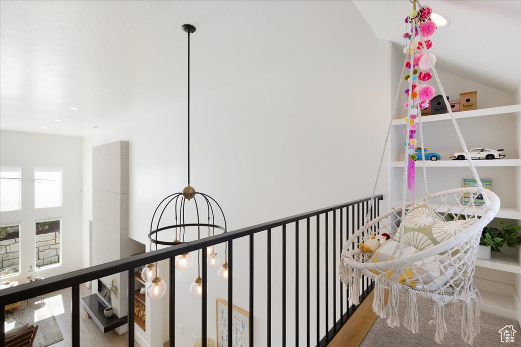 Hallway featuring wood finished floors, a chandelier, and an upstairs landing