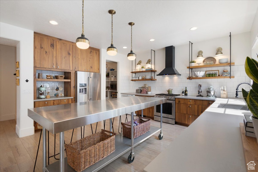 Kitchen with open shelves, wall chimney range hood, appliances with stainless steel finishes, stainless steel countertops, and recessed lighting
