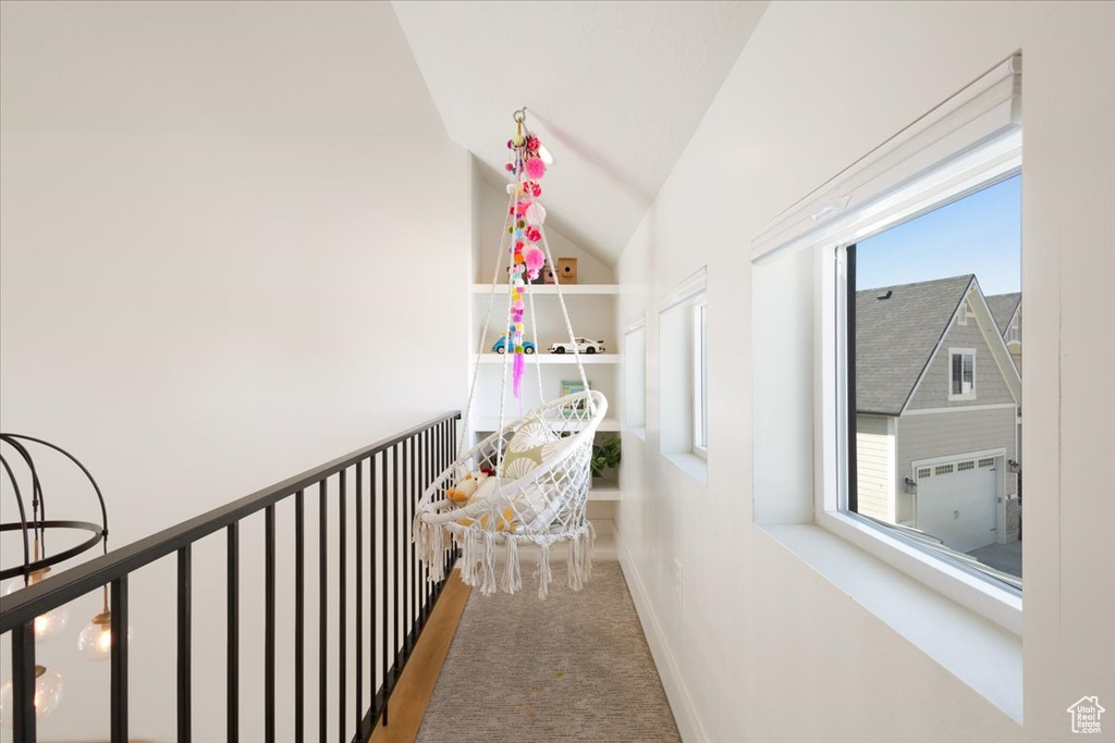 Hallway featuring carpet flooring and lofted ceiling