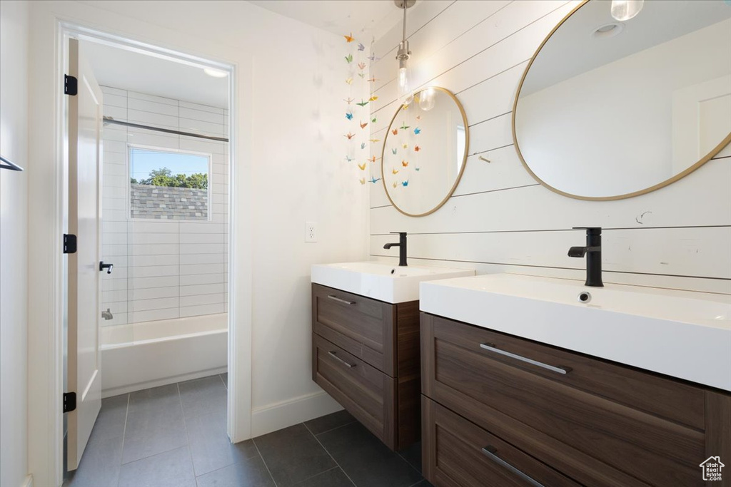 Full bath featuring tile patterned floors, two vanities, and tub / shower combination