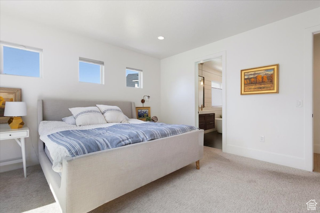 Carpeted bedroom with ensuite bathroom and recessed lighting