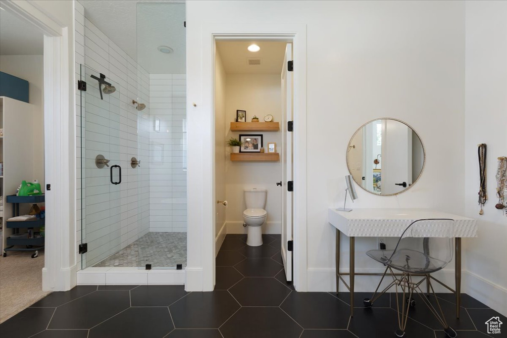 Bathroom with a shower stall and tile patterned floors