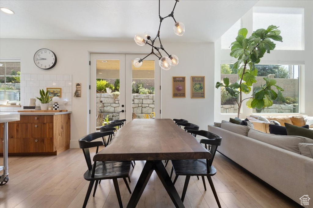 Dining area featuring french doors, light wood finished floors, and a chandelier