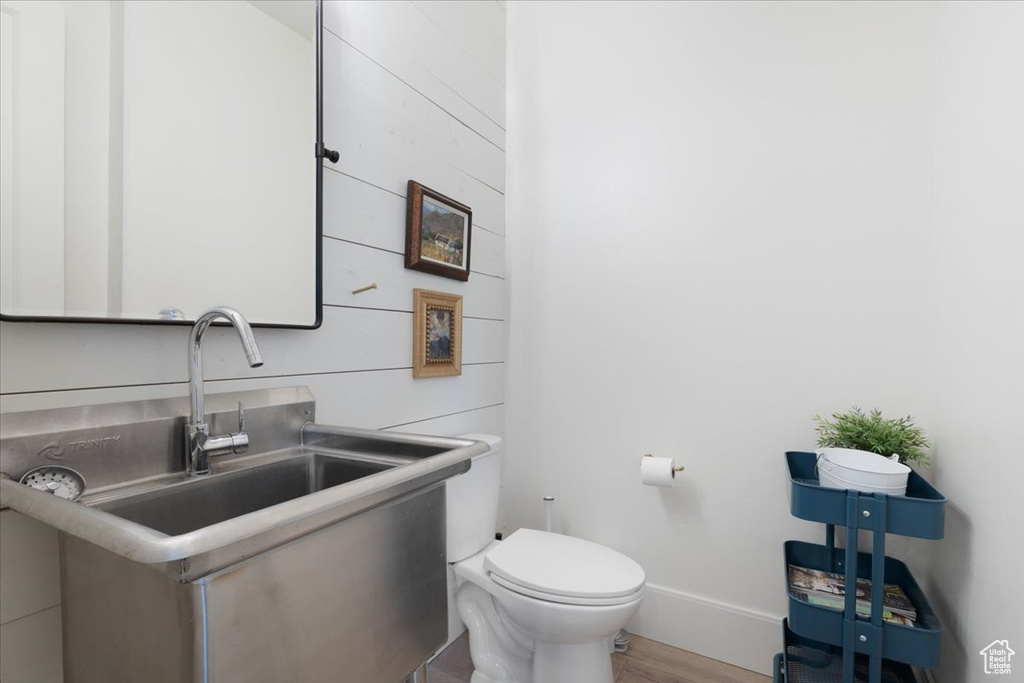 Half bath with wood finished floors and vanity
