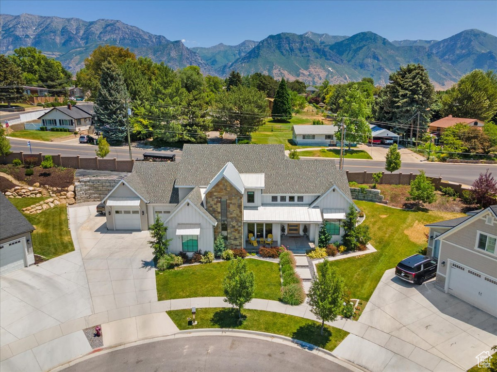 Aerial view of property and surrounding area featuring a mountain backdrop