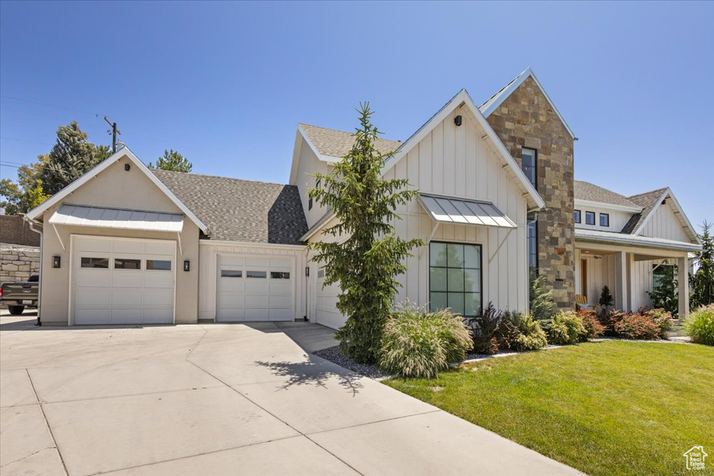 Modern farmhouse style home with a standing seam roof, concrete driveway, an attached garage, and board and batten siding