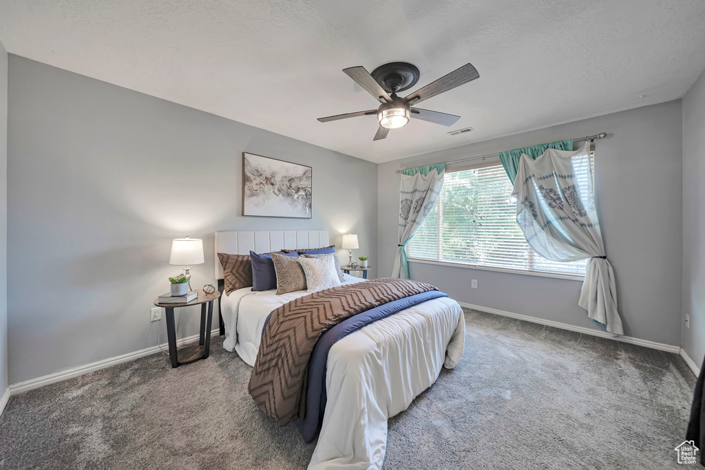 Carpeted bedroom featuring baseboards and ceiling fan