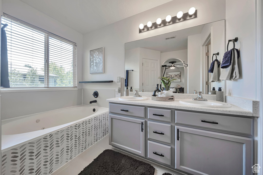 Full bathroom featuring double vanity, a garden tub, and tile patterned flooring
