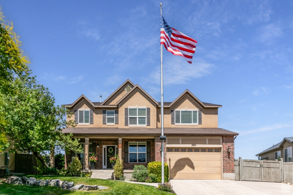 View of front of house with concrete driveway, a garage, brick siding, and stucco siding