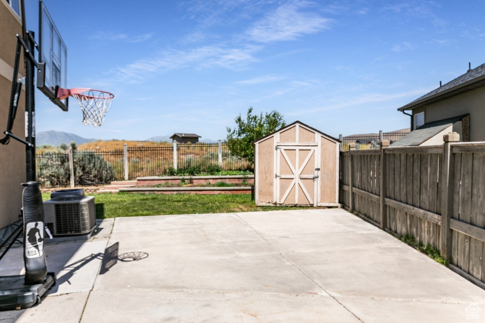 Fenced backyard featuring a shed and a patio area