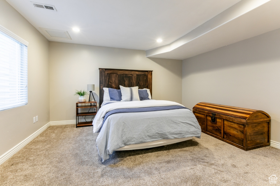 Carpeted bedroom featuring multiple windows and recessed lighting