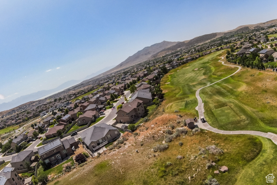 Aerial view of property and surrounding area featuring nearby suburban area and a mountain backdrop