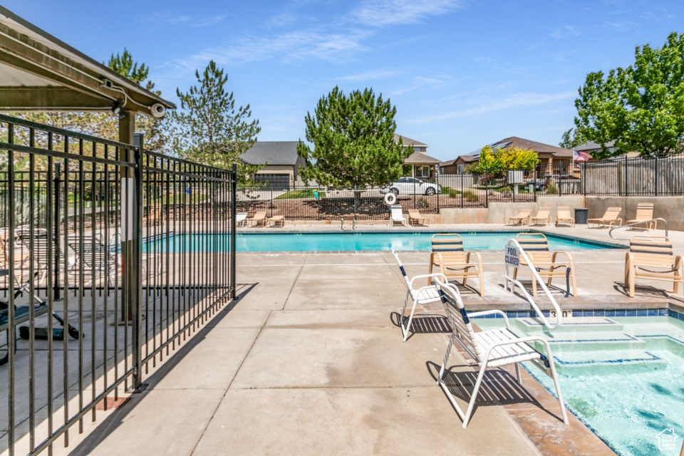 Community pool featuring a community hot tub and a patio