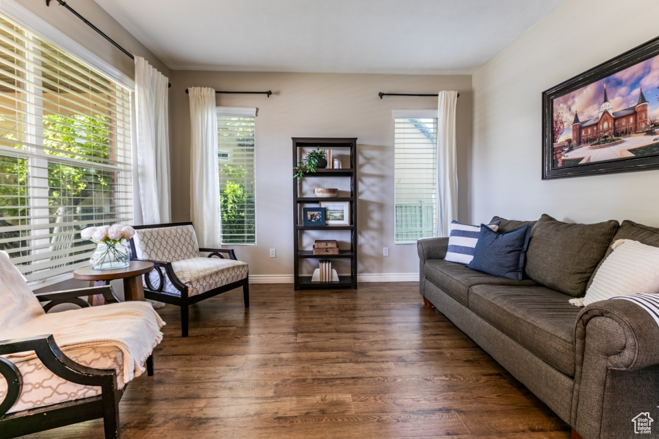 Living area featuring dark wood-style flooring and baseboards