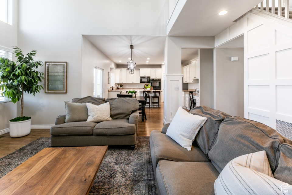 Living room featuring wood finished floors, plenty of natural light, a high ceiling, and recessed lighting