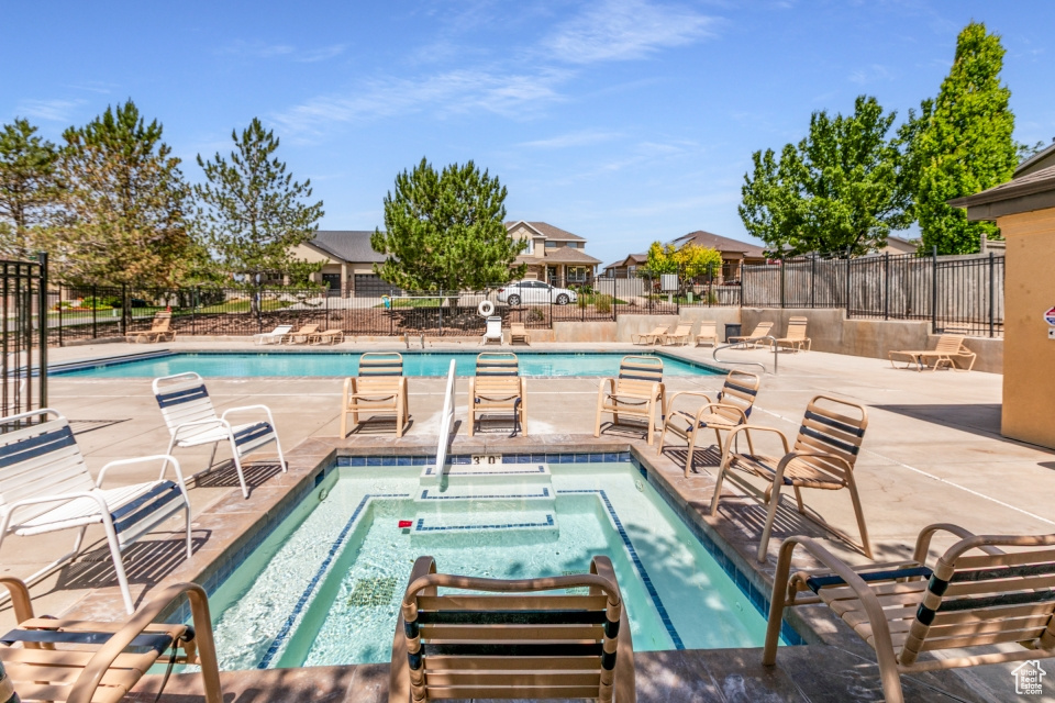 Community pool with a patio and a hot tub