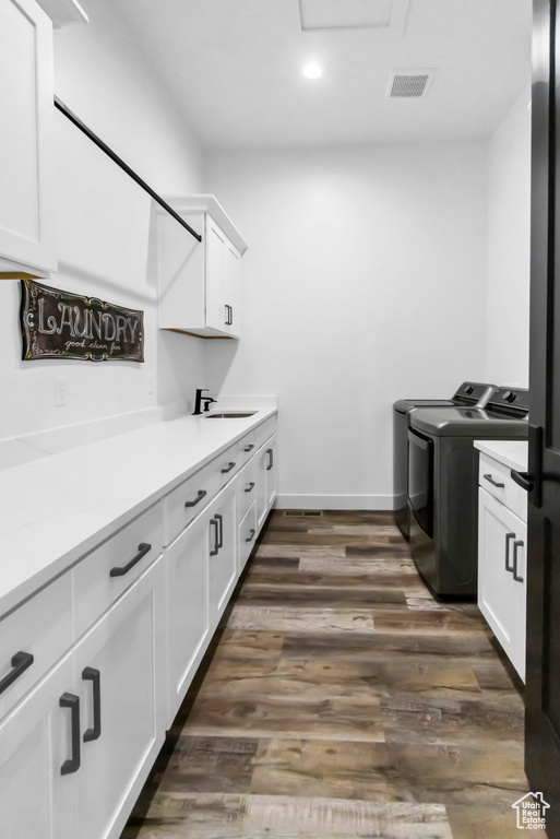 Laundry area with washer and clothes dryer, cabinet space, recessed lighting, and dark wood-type flooring