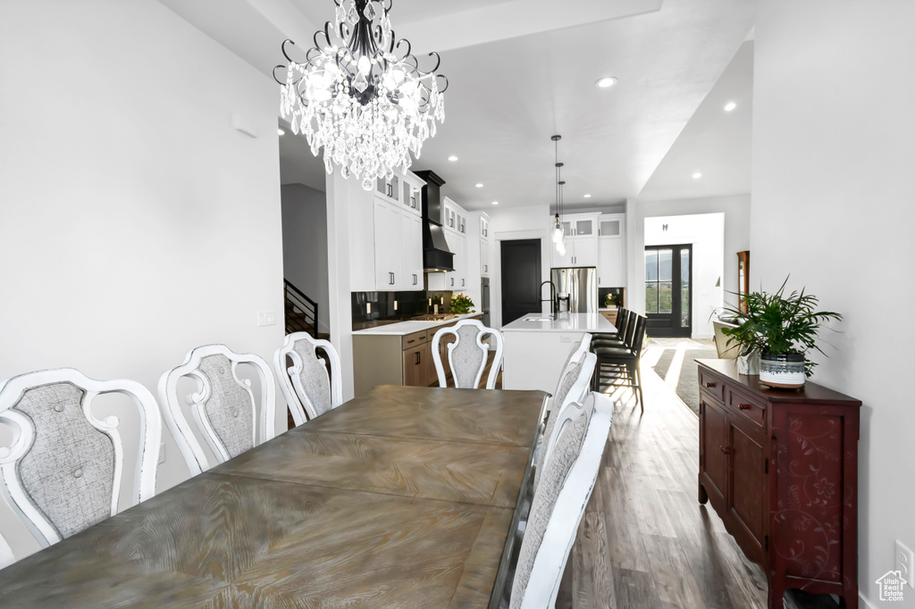 Dining area with recessed lighting, wood finished floors, and a chandelier