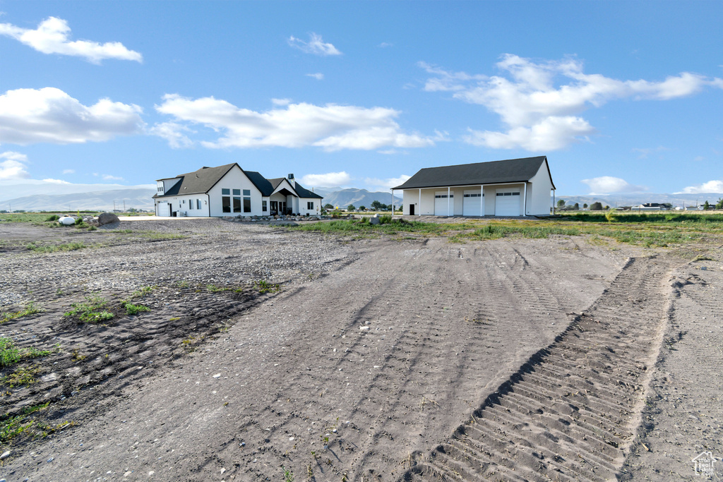 View of front of home featuring a detached garage, driveway, and an outdoor structure