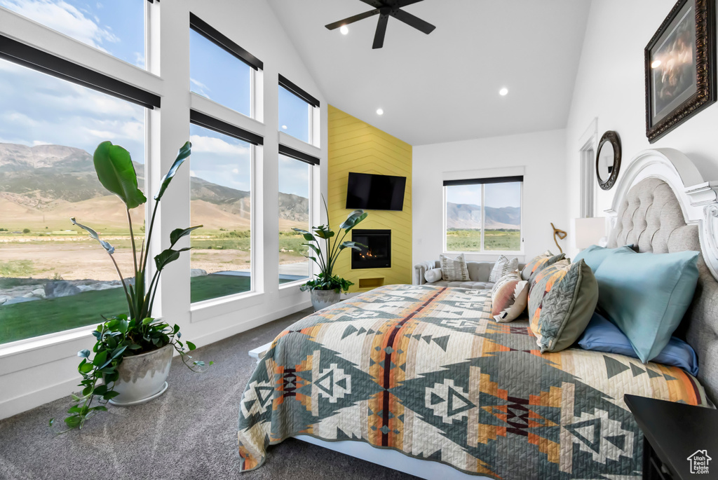 Bedroom featuring high vaulted ceiling, multiple windows, carpet flooring, recessed lighting, and a fireplace
