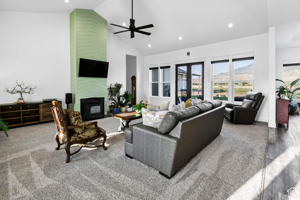 Living room featuring high vaulted ceiling, a ceiling fan, recessed lighting, a large fireplace, and carpet floors