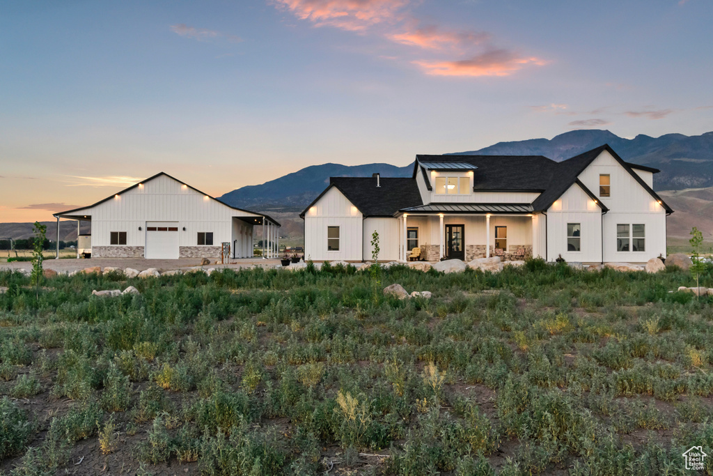 View of front of home with a standing seam roof, a mountain view, and board and batten siding
