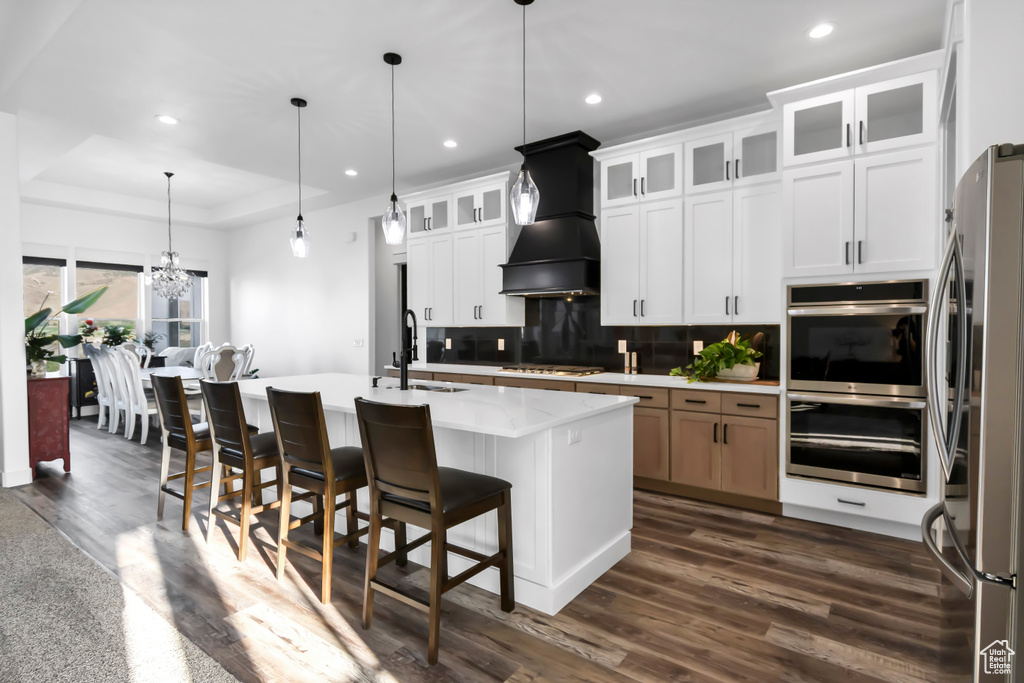 Kitchen with appliances with stainless steel finishes, recessed lighting, tasteful backsplash, dark wood-type flooring, and custom range hood