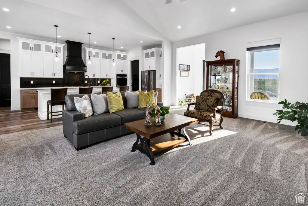 Carpeted living room featuring recessed lighting and vaulted ceiling